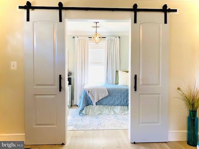 bedroom featuring a barn door and light wood-type flooring