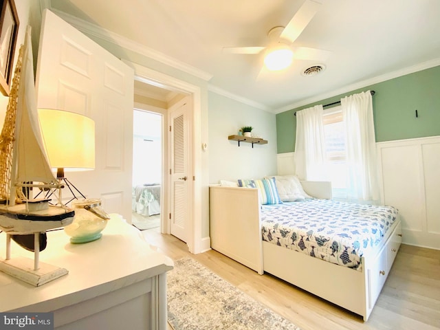 bedroom featuring ceiling fan, light hardwood / wood-style floors, and ornamental molding