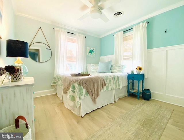 bedroom featuring ceiling fan, ornamental molding, and light wood-type flooring