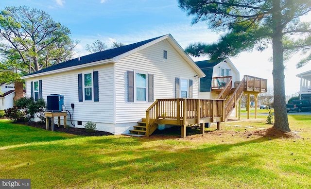 rear view of property with central AC, a deck, and a lawn