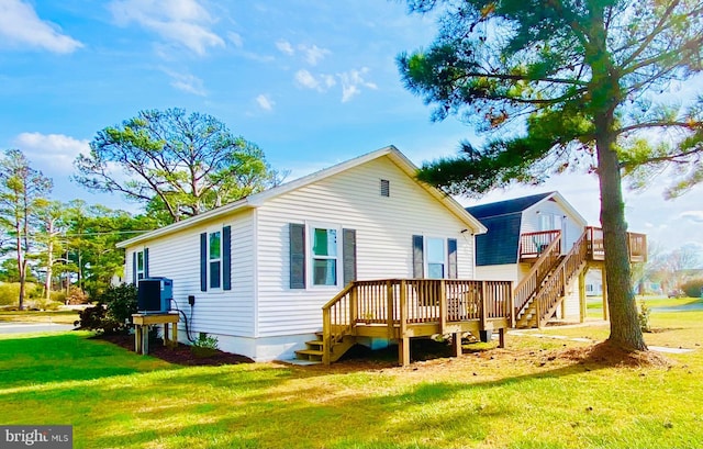 rear view of house with a yard and a wooden deck