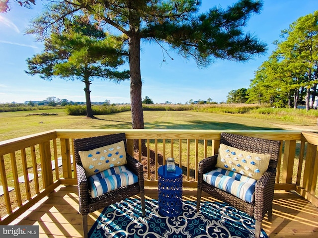 wooden deck featuring a rural view and a yard