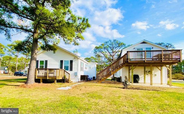 rear view of house with a yard and a wooden deck