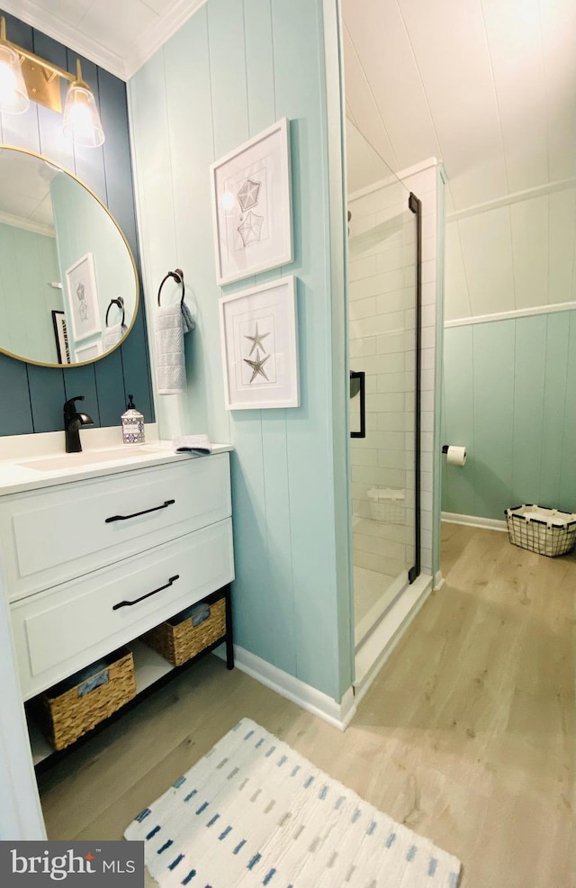 bathroom featuring ornamental molding, vanity, wood-type flooring, and walk in shower