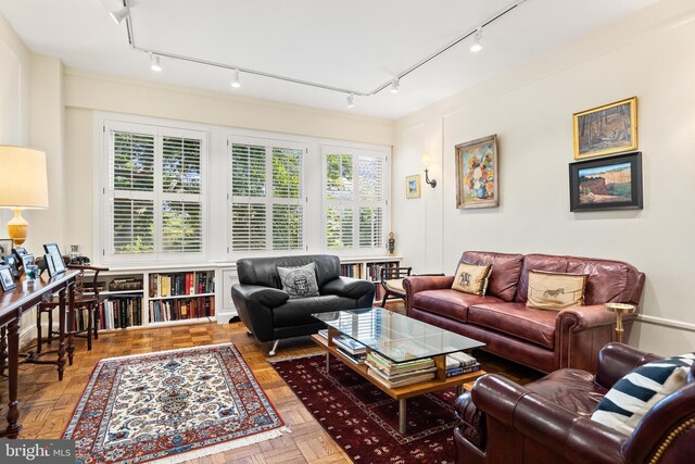 living room featuring track lighting, a wealth of natural light, and parquet flooring