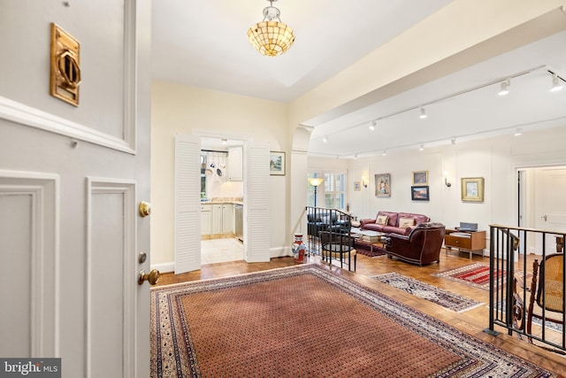 foyer with rail lighting and hardwood / wood-style floors