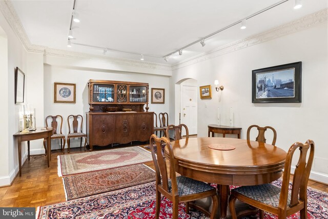 dining space with light parquet flooring and rail lighting