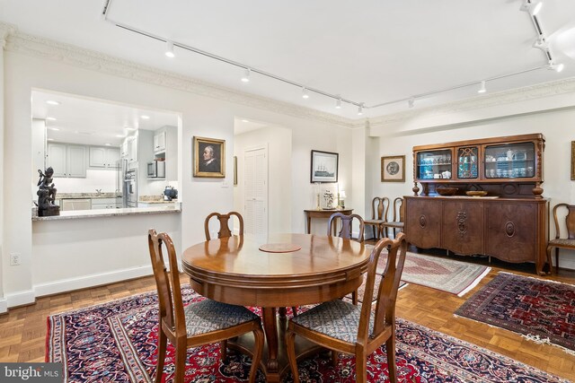 dining space featuring track lighting and parquet floors