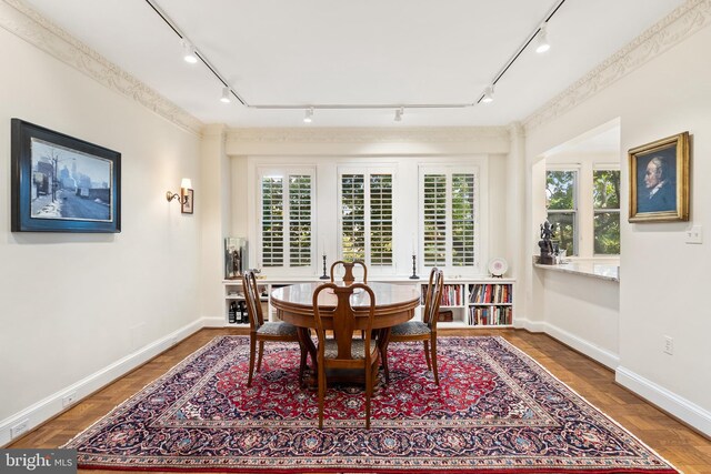 dining space with track lighting, a wealth of natural light, and hardwood / wood-style floors