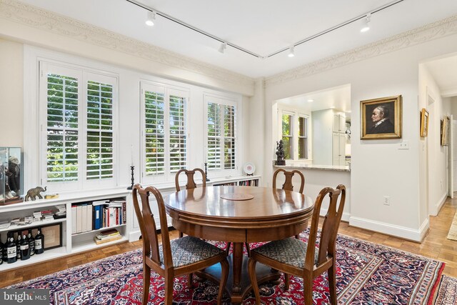 dining area with track lighting and light hardwood / wood-style floors