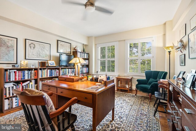 home office with ceiling fan and dark hardwood / wood-style flooring