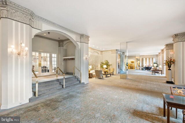 entrance foyer with ornamental molding, ornate columns, and a notable chandelier