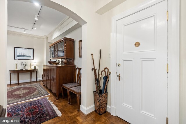 foyer with rail lighting and dark parquet flooring