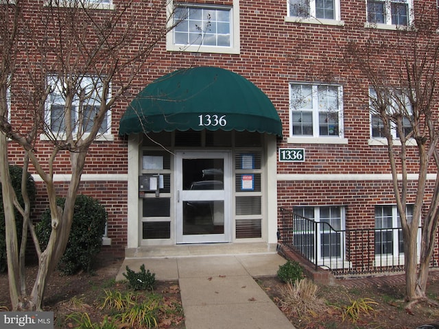 view of exterior entry featuring brick siding