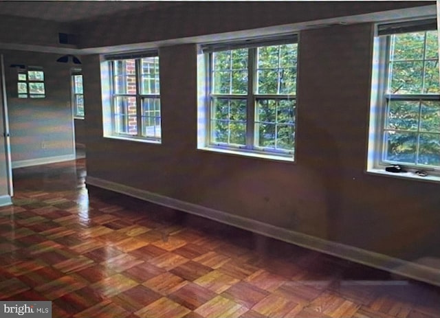 spare room featuring dark parquet flooring