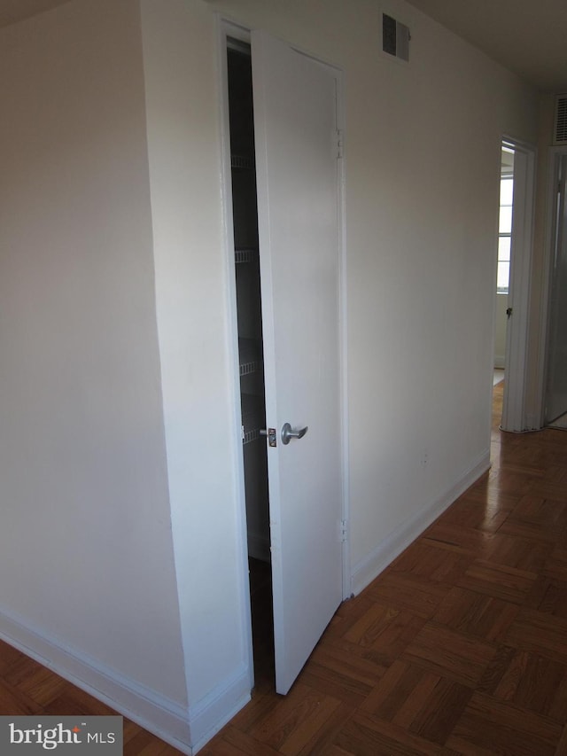 hallway featuring visible vents and baseboards