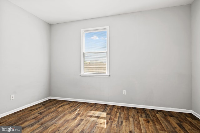 unfurnished room with dark wood-style floors and baseboards