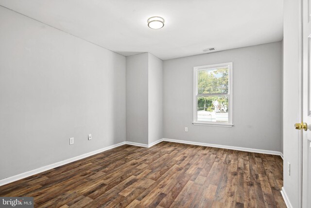 spare room featuring dark wood-type flooring