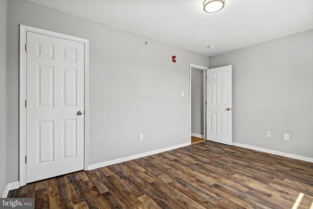 empty room with dark hardwood / wood-style flooring