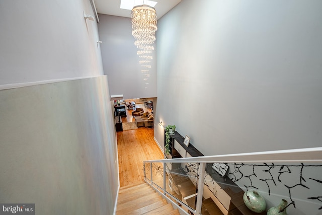 stairway featuring a chandelier and wood finished floors