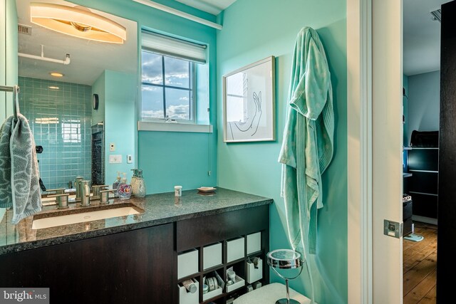 bathroom featuring wood-type flooring, an enclosed shower, and vanity