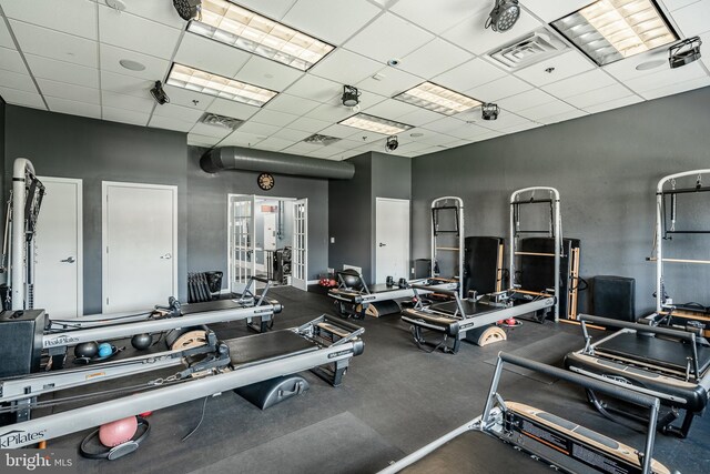 exercise room featuring french doors and a drop ceiling