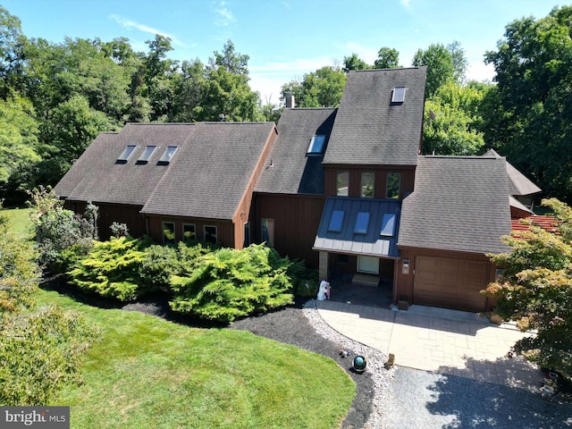 view of front of home with concrete driveway, a front lawn, a garage, and a shingled roof