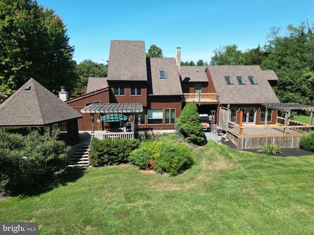 rear view of house featuring a chimney, a pergola, a yard, and a shingled roof