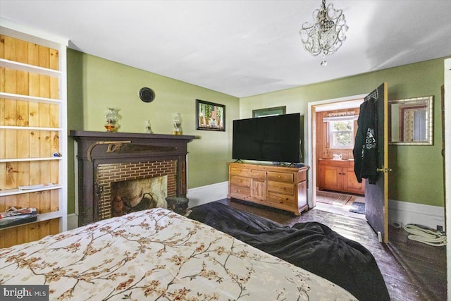 bedroom with hardwood / wood-style flooring and a brick fireplace