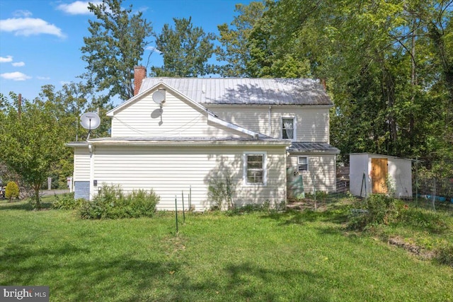 rear view of house with a lawn and a storage unit