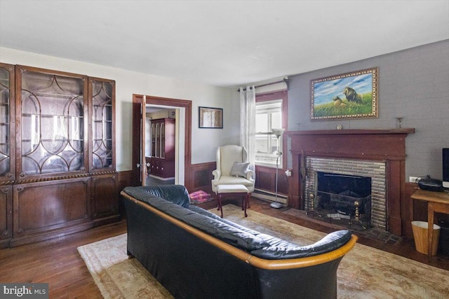 living room featuring a baseboard heating unit and dark hardwood / wood-style flooring