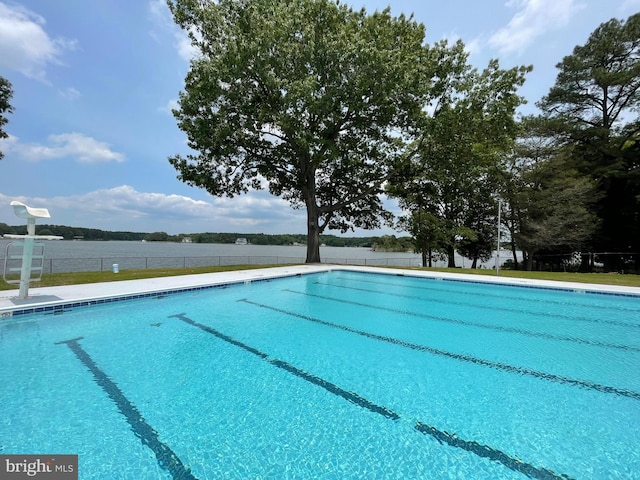 view of swimming pool with a water view, fence, and a fenced in pool