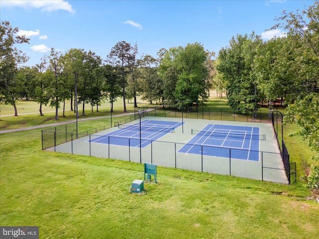 view of sport court with fence and a yard