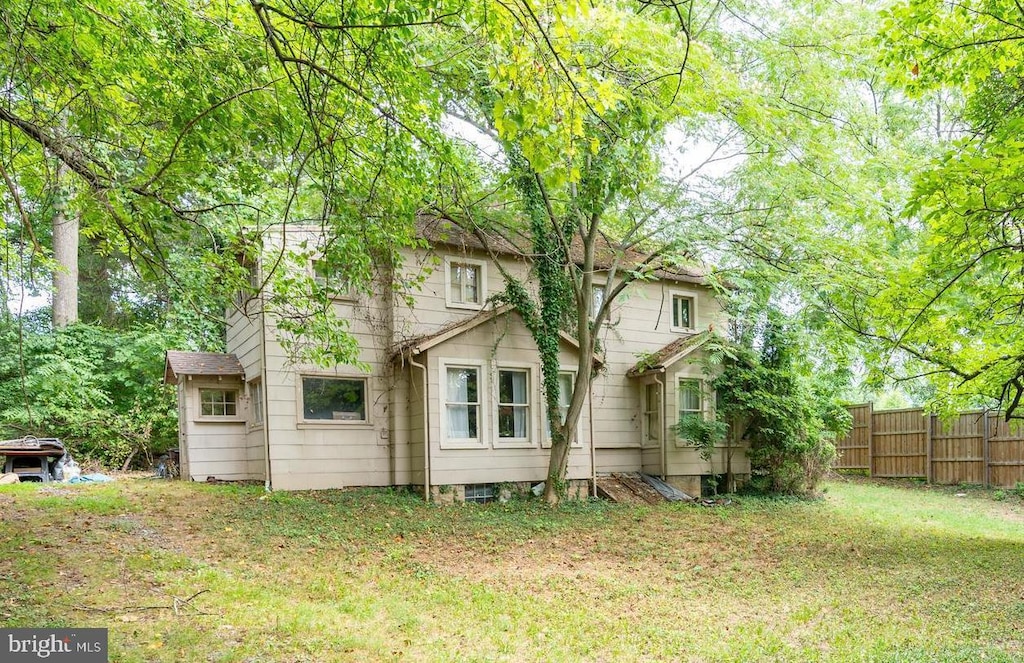 back of house featuring a yard and fence