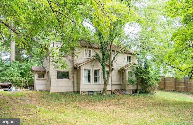 back of house featuring a yard and fence