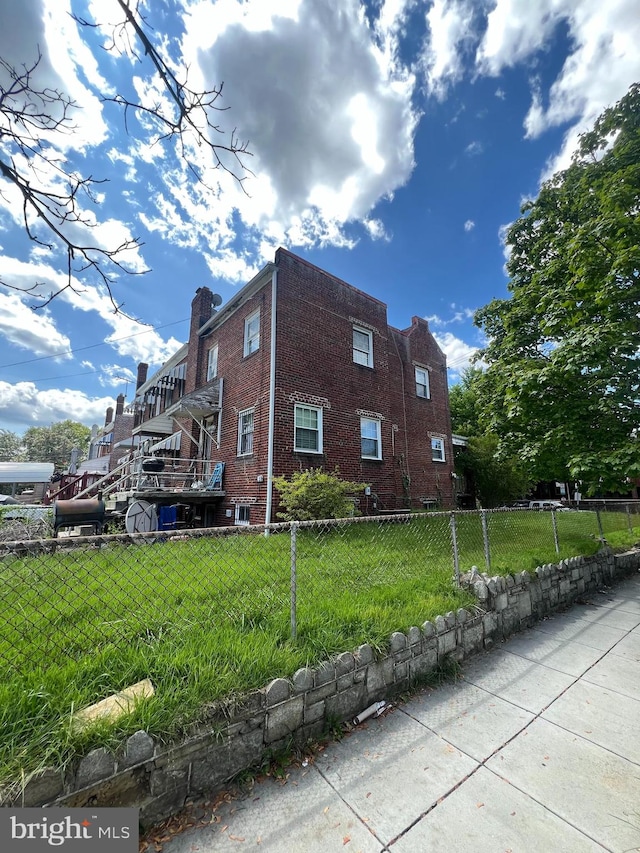 view of side of home with a yard and central AC