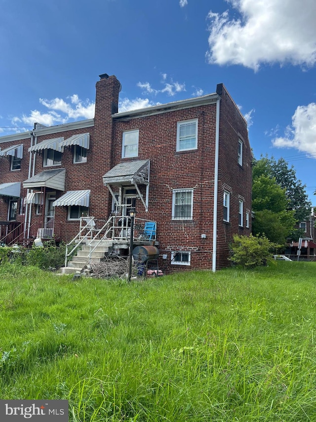 rear view of property with a lawn