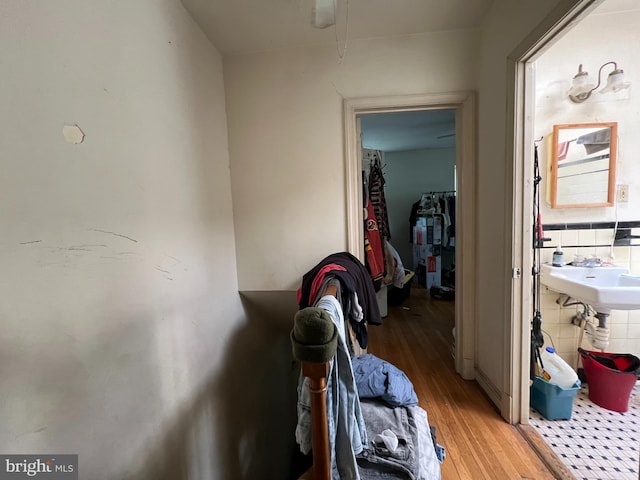 hall with tile walls and light hardwood / wood-style floors