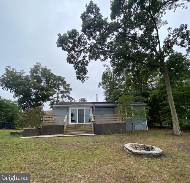 view of front of property featuring an outdoor fire pit and a front lawn