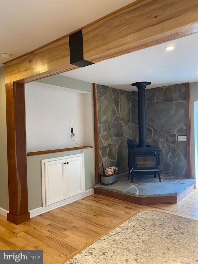 unfurnished living room with a wood stove and hardwood / wood-style floors