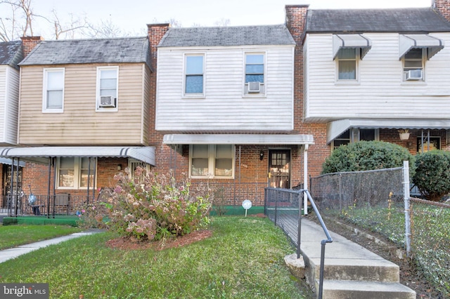 multi unit property featuring a front yard, cooling unit, and brick siding