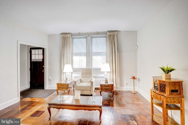 sitting room featuring radiator heating unit and hardwood / wood-style flooring