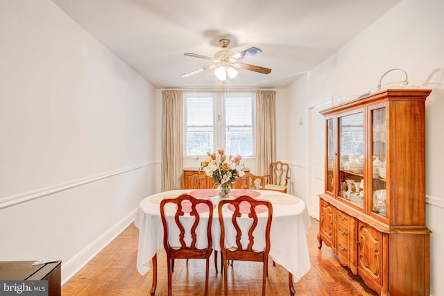 dining space featuring a ceiling fan and baseboards