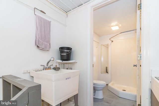 bathroom with concrete floors, toilet, sink, and walk in shower