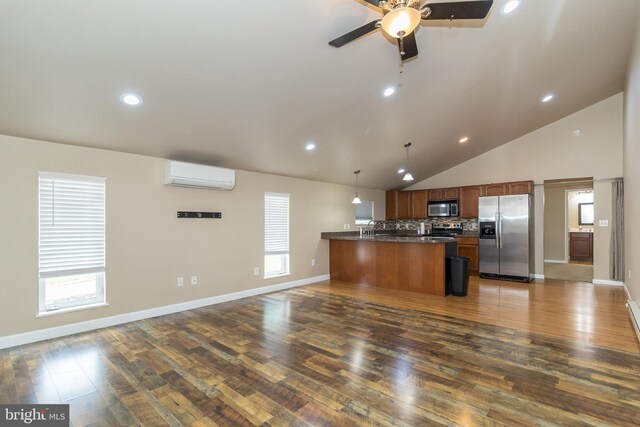 kitchen with a wall mounted AC, hanging light fixtures, stainless steel appliances, dark wood-type flooring, and ceiling fan