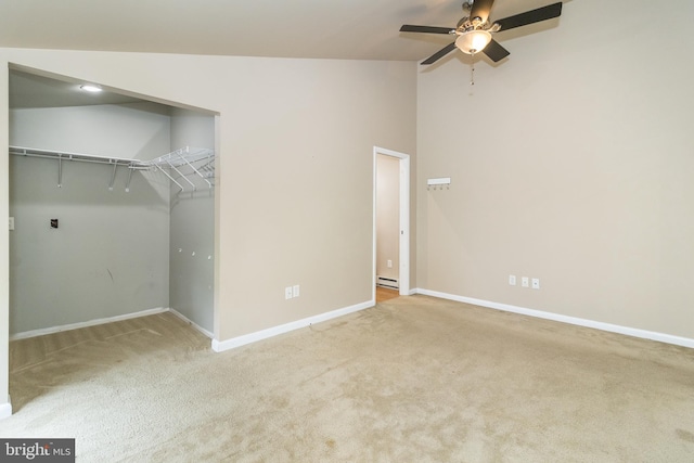 unfurnished bedroom featuring lofted ceiling, a closet, a baseboard radiator, carpet, and ceiling fan