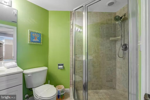 bathroom with toilet, an enclosed shower, and vanity