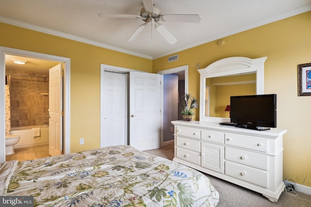 carpeted bedroom with crown molding, ceiling fan, and ensuite bath