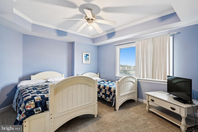 carpeted bedroom with crown molding, ceiling fan, and a raised ceiling