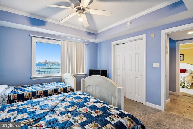 bedroom with ceiling fan, a textured ceiling, a closet, and carpet floors